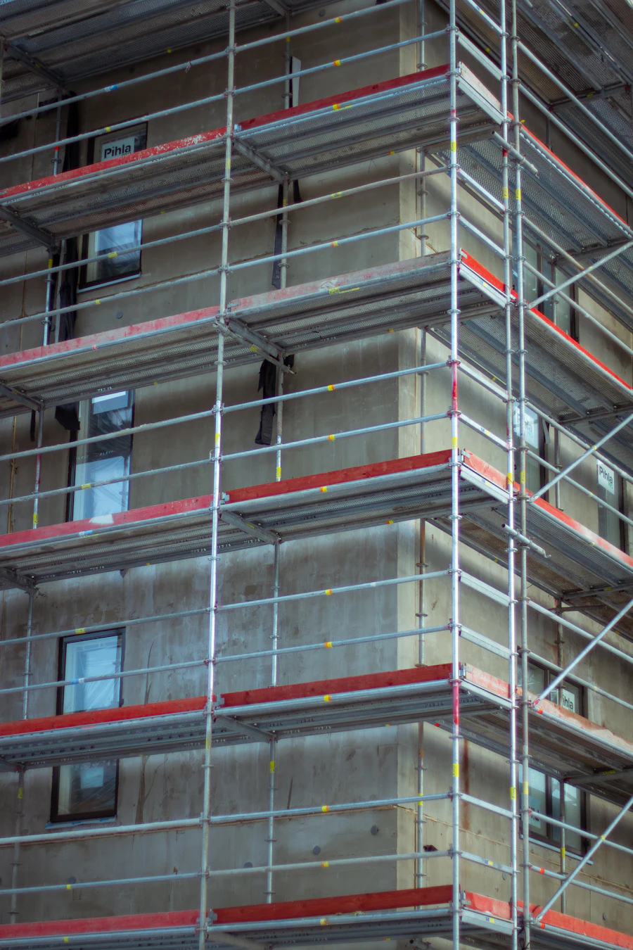 Building wrapped in scaffolding with red toe-boards