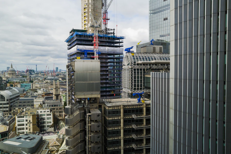 High-rise office tower under construction with a crane beside a city skyline