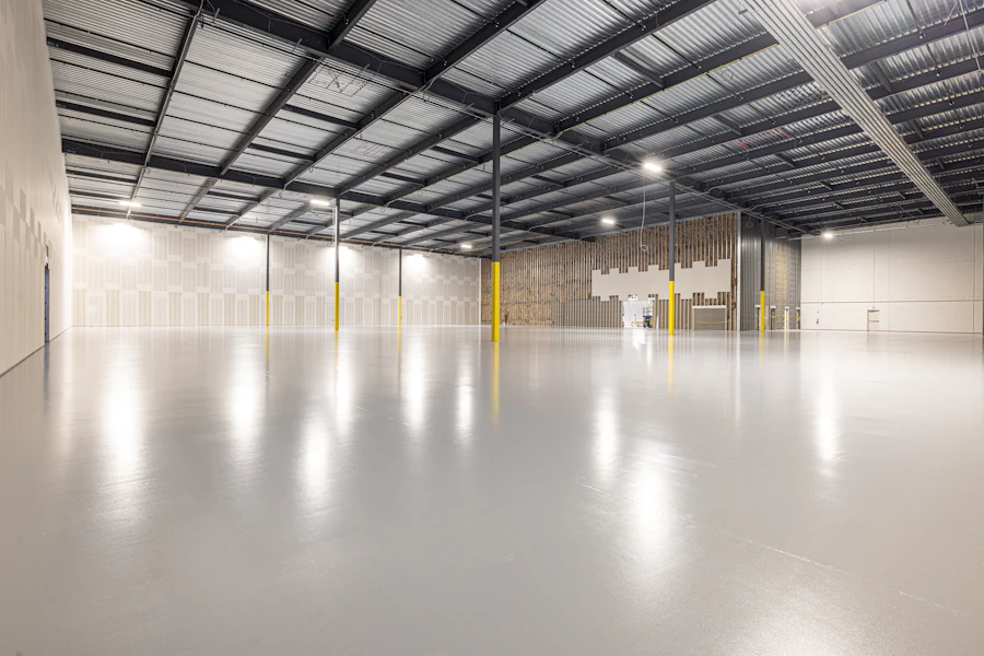 Bright new warehouse interior with a polished floor and steel roof trusses